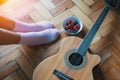 Parquet floor guitar, ÃÂup of strawberries, female feet in pink socks. Relax.